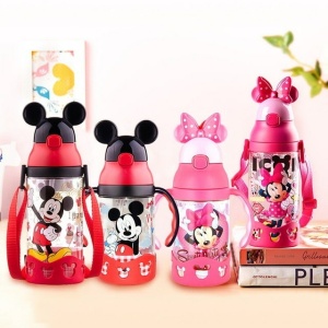 Bottiglia Mickey per bambini in rosso e rosa su un tavolo con parete bianca