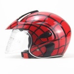 Casco per bambini con visiera frontale. Il casco ha un motivo a ragnatela rossa che ricorda Spiderman. Il casco è dotato di una clip in basso per fissarlo.