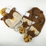 Cappello e sciarpa in maglia marrone e beige per bambini con motivo di uccelli su sfondo bianco