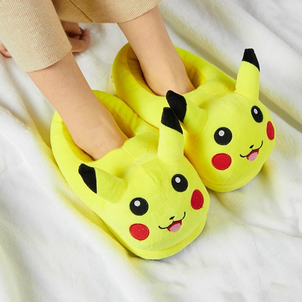 Pantofole per bambini a forma di Pikachu di peluche, infilate sui piedi con una coperta bianca