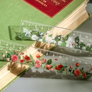 Righello dritto da 15 cm con disegno di fiore trasparente per bambini su un libro in verde