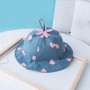 Cappello estivo in pizzo blu per bambini con fiori rosa su un tavolo bianco