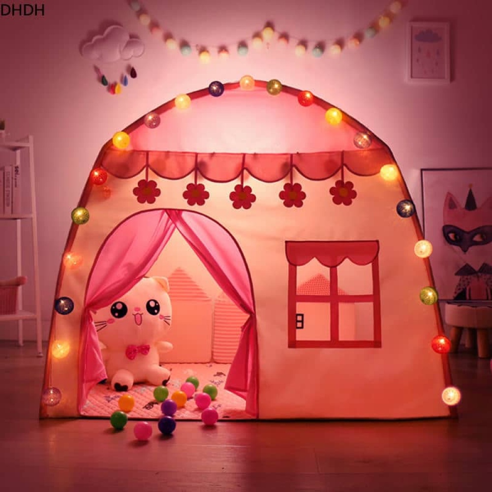 Casa tepee rosa del principe o della principessa, con giocattoli coccolosi all'interno e luci
