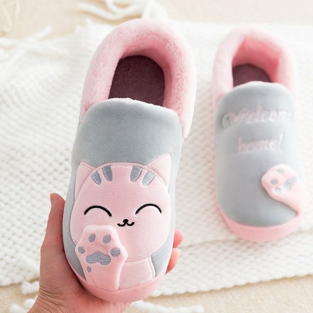 Pantofole da gatto per bambini grigie con disegno rosa su una mano con coperta bianca