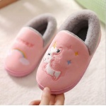 Pantofole a forma di unicorno rosa e grigio su un tappeto bianco