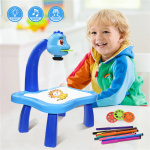 Tavolo da disegno con lavagna luminosa di colore blu con bambino sorridente e penne colorate