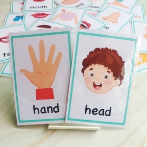 Gioco di carte per bambini con mano e testa e altre carte su un letto