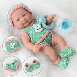 Bambola morbida per neonati con vestiti verdi e rosa su un cappotto bianco