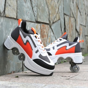 Scarpe da pattinaggio a rotelle per bambini in bianco e nero arancione davanti a un muro di pietra