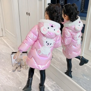 Giacca lunga e lucida con cappuccio a forma di orsacchiotto per ragazze in rosa con orsetto nel cappuccio e sulla schiena su una ragazza davanti allo specchio