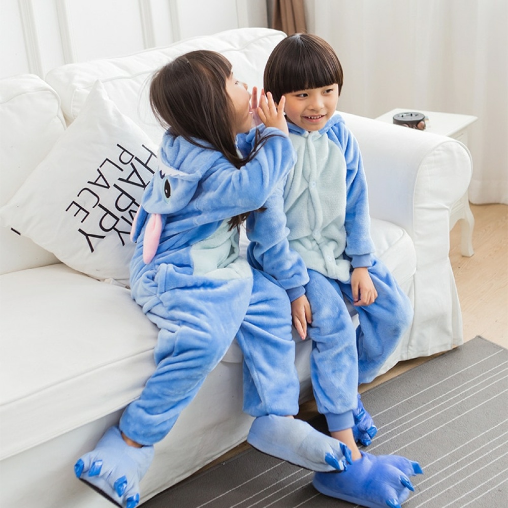 Pigiama caldo a punto blu dei cartoni animati per bambini con 2 bambini su un divano bianco