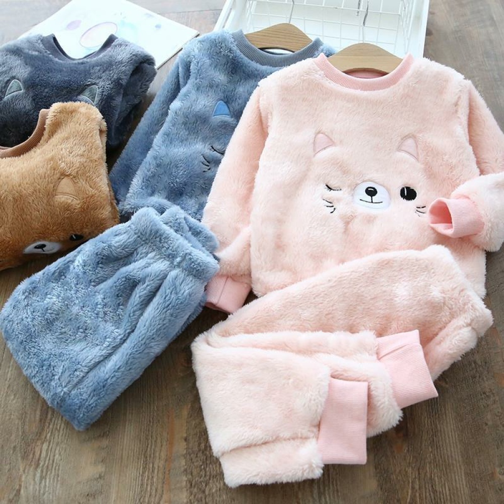 Set di pigiami con gatti caldi rosa e blu per bambini su un tavolo di legno
