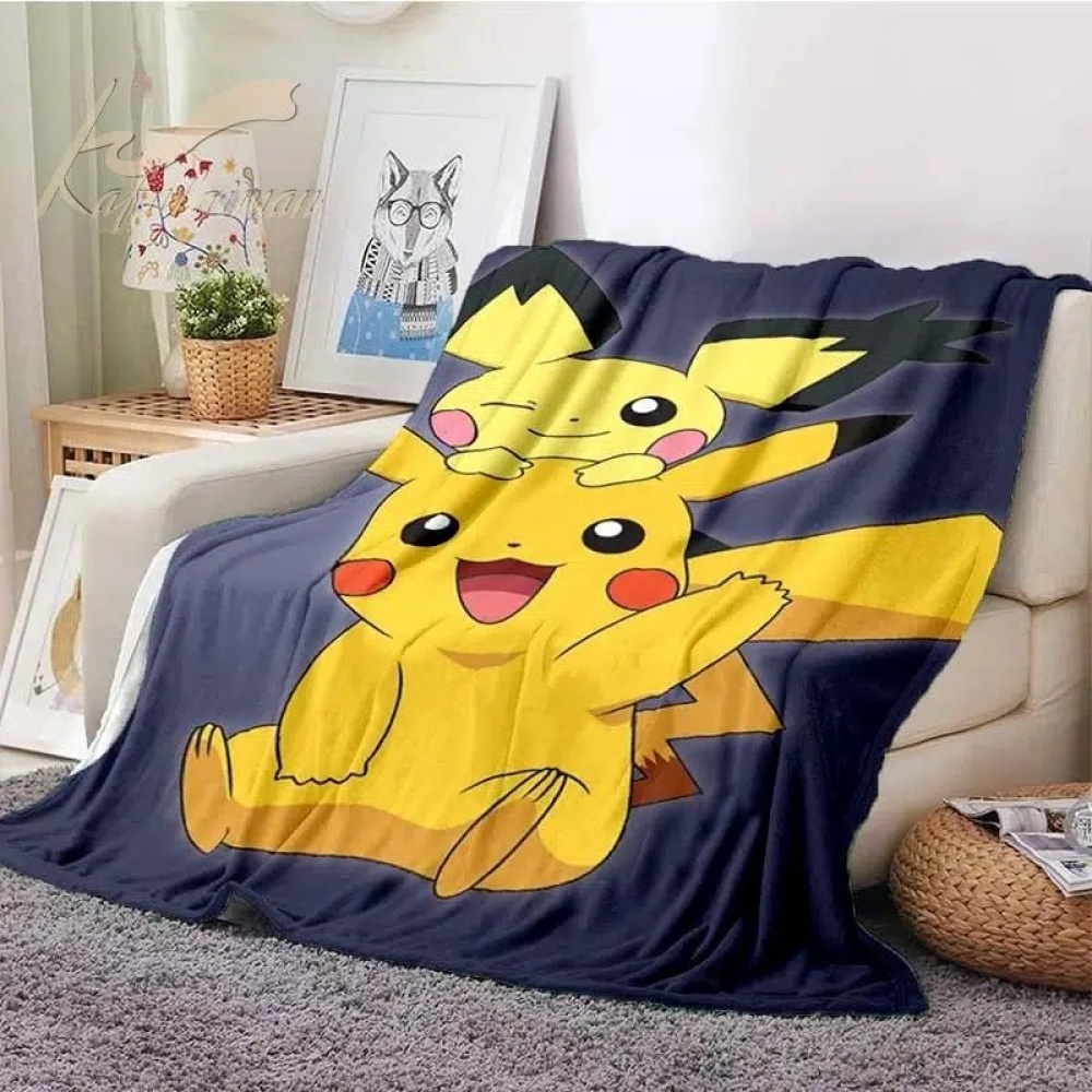Coperta Pokémon Pichu e Pikachu per bambini in nero e giallo su un divano beige
