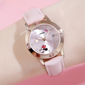 presentato su un braccio, l'orologio da ragazza Minnie con cinturino rosa chiaro e quadrante d'oro circondato da un'immagine di colore rosso