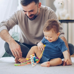 Gioco di dentizione in silicone Montessori per bambini con sfondo, un papà con il suo bambino