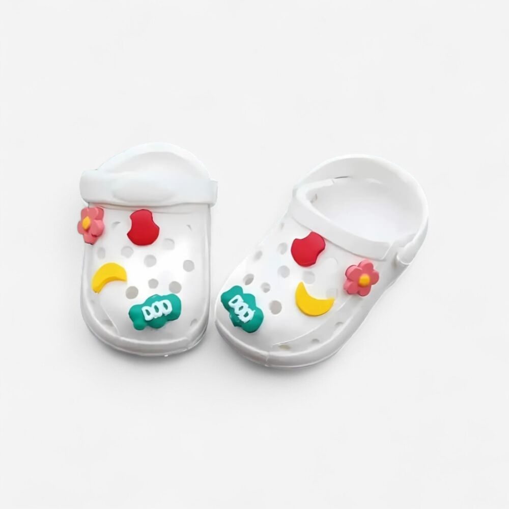 IMG_1100x1100_mini_sabots_style_crocs_poupee_labubu8.jpg Mini zoccoli bianchi per bambola Labubu, stile Crocs con motivi giocosi decorativi, su sfondo bianco.