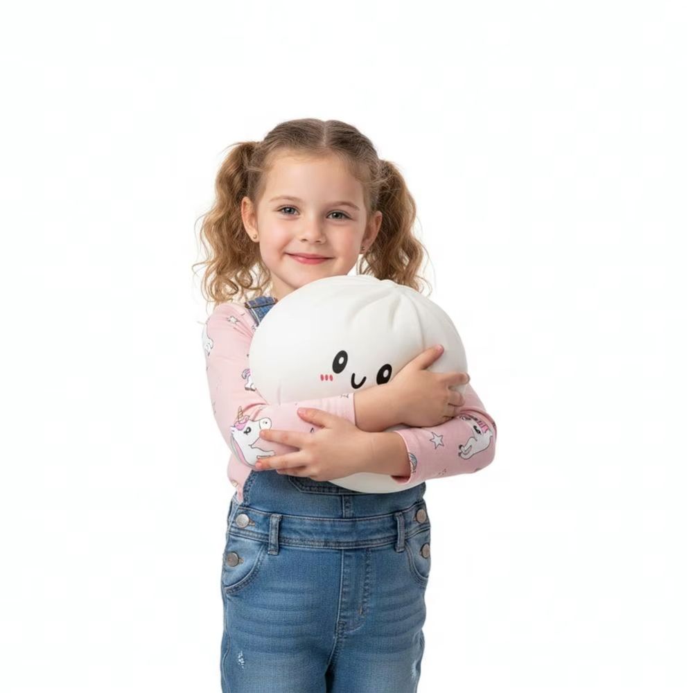 IMG_squishy_dumpling_blanc_geant_anti_stress.jpg Jeune fille avec des couettes portant un jean et un t-shirt rose, se tient debout avec dans les bras un squishy dumpling blanc géant.